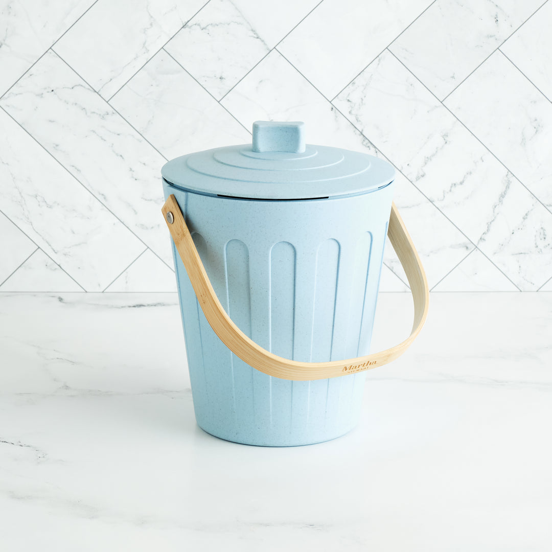 Light blue trash bin with a beige handle on a white background