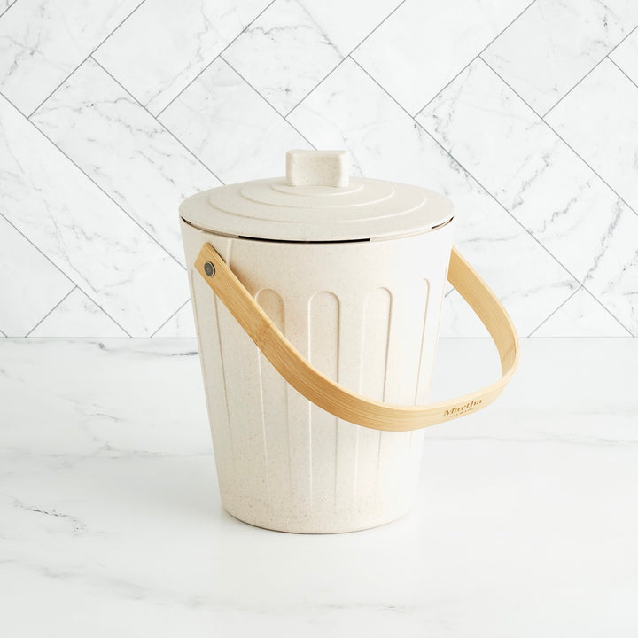 White trash bin with a wooden handle on a white marble background